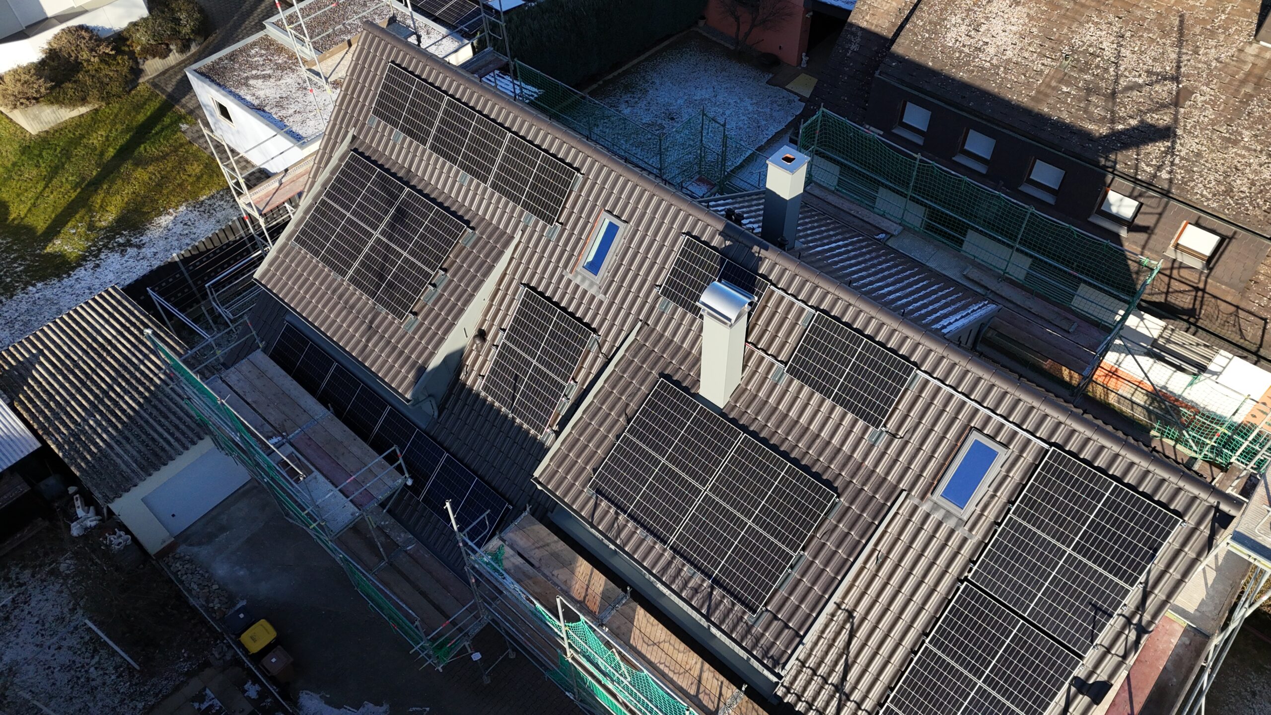 Luftaufnahme eines Wohnhausdachs mit neu montierten Photovoltaikmodulen